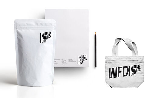 Deutsch – Bildbeschreibung (SEO / Metadaten) Anwendungsdarstellung des Corporate Designs für den World Fitness Day. Das Logo ist in Schwarz-Weiß eingesetzt und erscheint auf einer Tragetasche, einer Verpackung für Nahrungsergänzungsmittel sowie auf Briefpapier. Die reduzierte Anwendung zeigt die Skalierbarkeit und Funktionalität des Designsystems über unterschiedliche Medien hinweg. ⸻ English – Image description (SEO / metadata) Application view of the corporate design for the World Fitness Day. The logo is shown in black and white across a tote bag, a nutritional supplement package, and stationery. The reduced execution highlights the scalability and versatility of the design system across different formats.