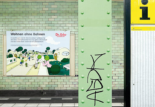 Deutsch – Bildbeschreibung (SEO / Metadaten) Beleuchtete Werbetafel im U-Bahnhof Samariterstraße als Teil des Kunstprojekts „Ey Werbung, was ist los?“. Das Plakat zeigt den Schriftzug „Wohnen ohne Bohnen – Doktor Erbs Immobilien“ und ist mit einer Illustration von Ulrich Scheel gestaltet. Das Motiv imitiert klassische Immobilienwerbung, verzichtet jedoch auf reale Verortung und Absenderlogik und ist Teil der experimentellen Plakatintervention im öffentlichen Raum. ⸻ English – Image description (SEO / metadata) Illuminated advertising display at Samariterstraße underground station in Berlin, part of the art project “Ey Werbung, was ist los?”. The poster reads “Wohnen ohne Bohnen – Doktor Erbs Immobilien” and features an illustration by Ulrich Scheel. The visual references familiar real estate advertising aesthetics while deliberately avoiding clear attribution, forming part of an experimental poster intervention in public space.